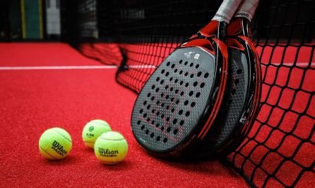 Équipement de padel professionnel avec raquettes et balles Wilson sur un court rouge, essentiel pour tout business plan pour padel.